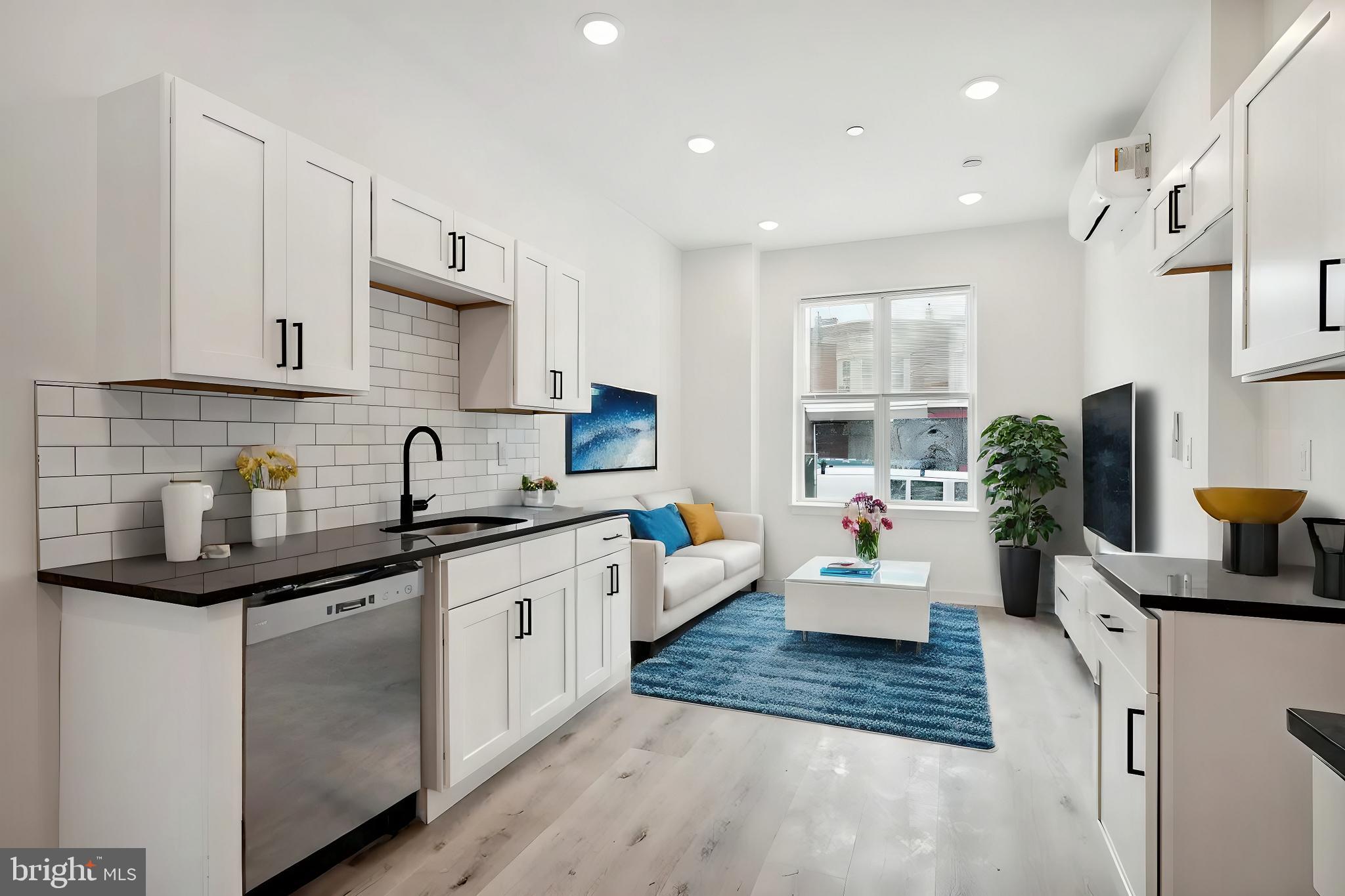 a kitchen with white cabinets a sink dishwasher and a stove with wooden floor