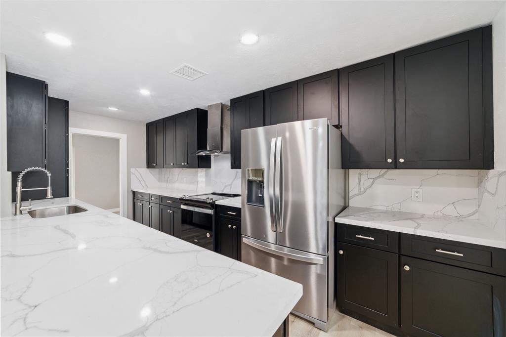 a kitchen with stainless steel appliances a refrigerator sink and stove