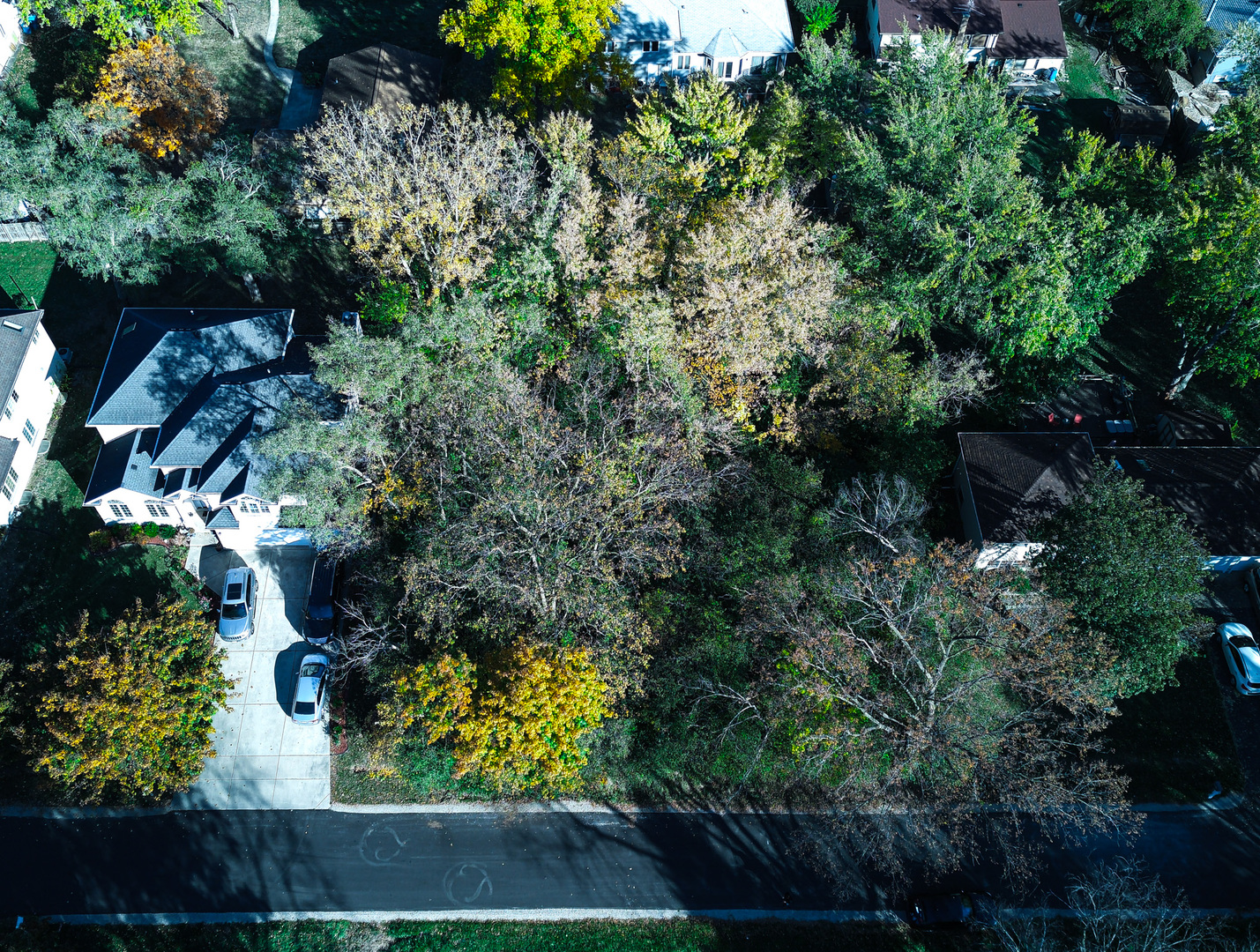 an aerial view of residential house with outdoor space and trees all around