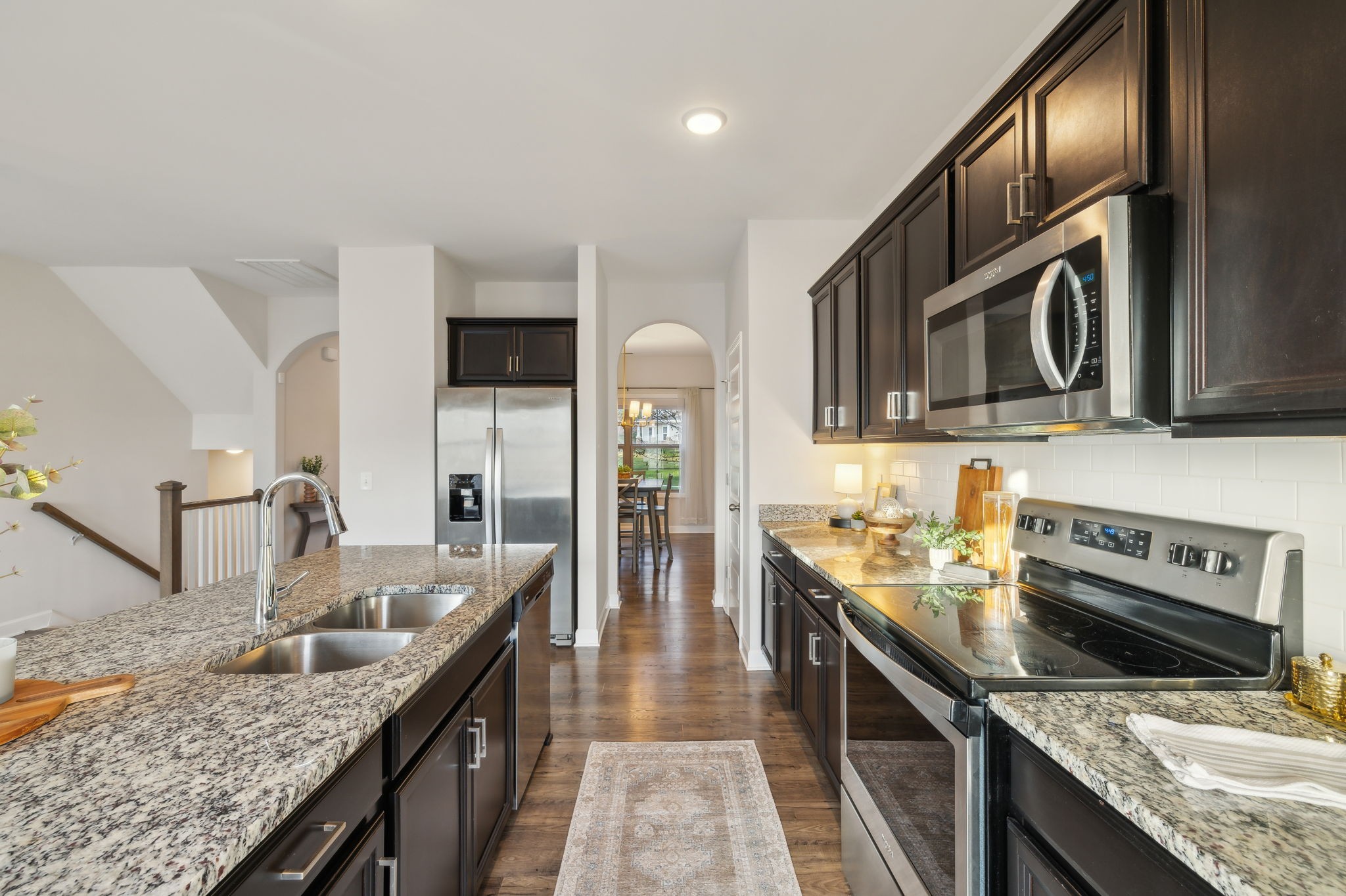 a kitchen with stainless steel appliances granite countertop a sink stove and refrigerator