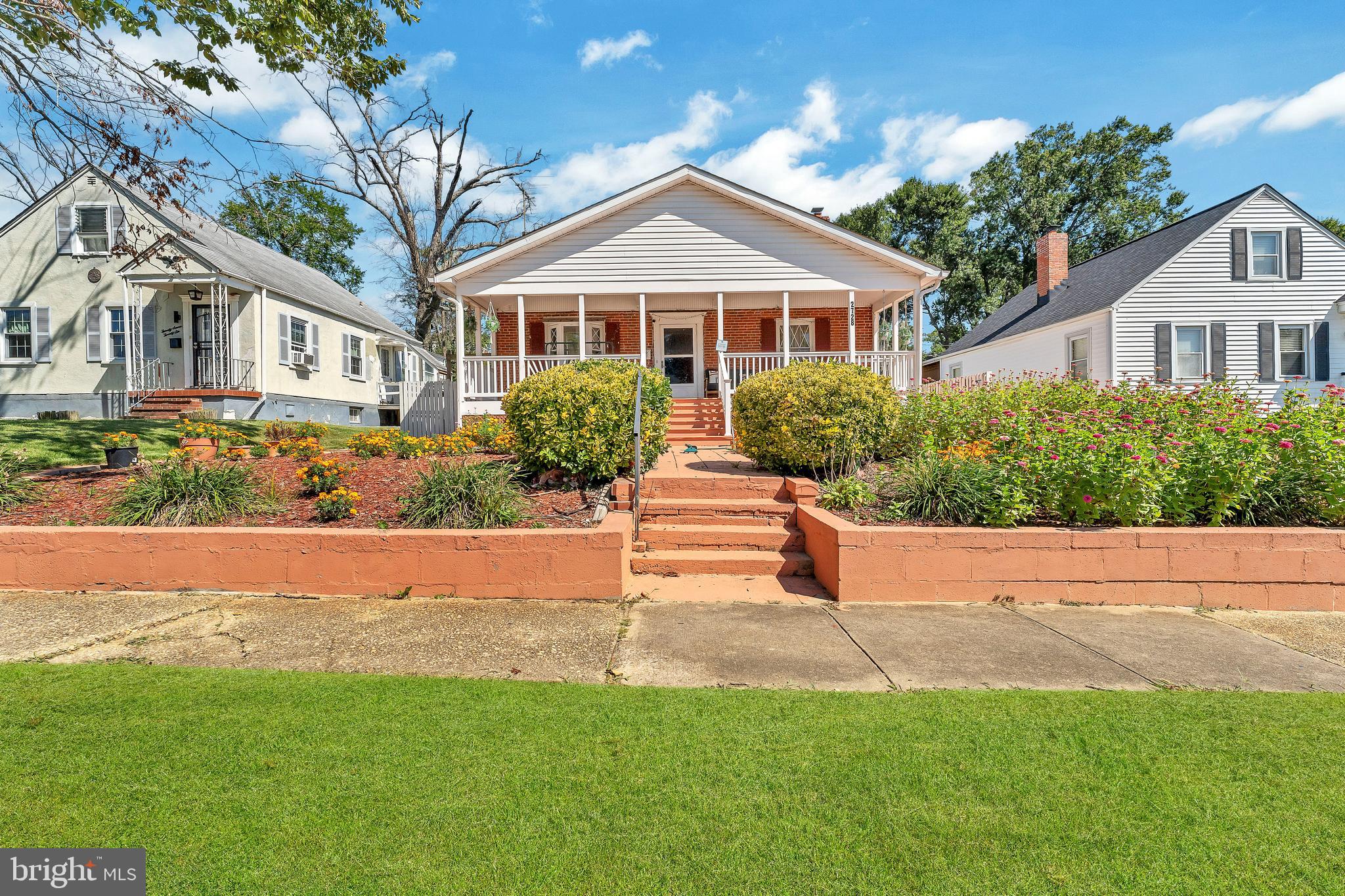 a front view of a house with a yard and potted plants