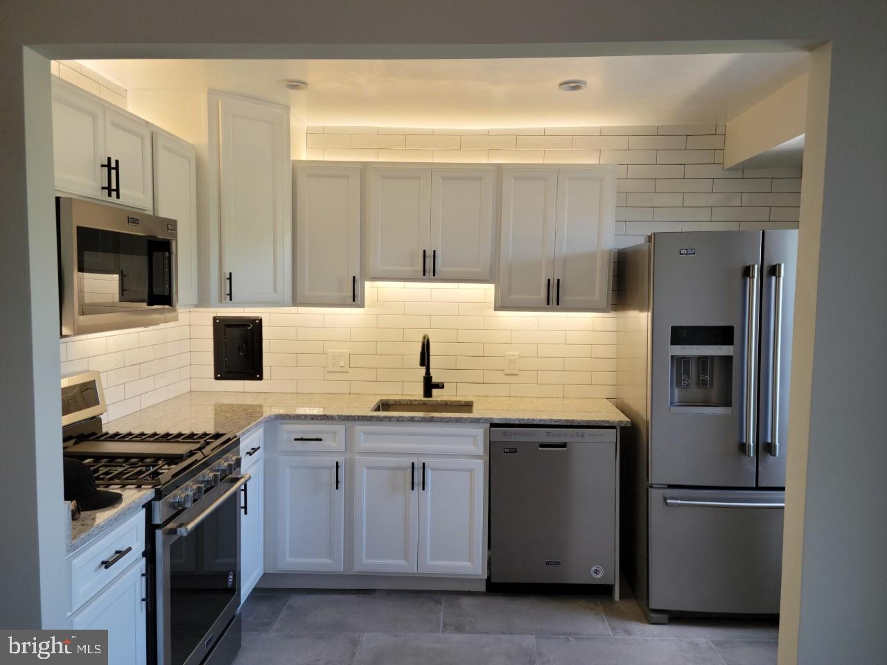 a kitchen with granite countertop a stove and a refrigerator