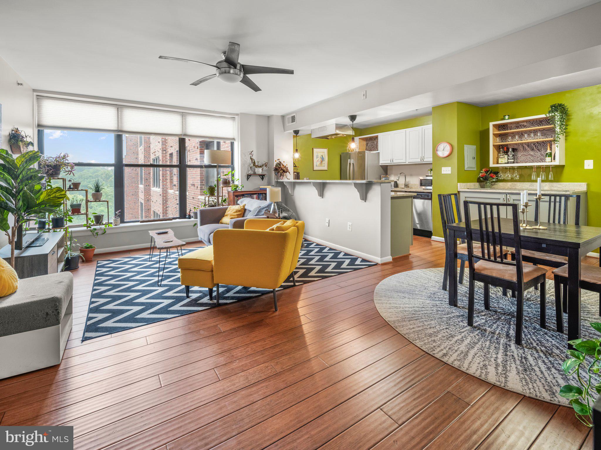 a living room with furniture floor to ceiling window and wooden floor