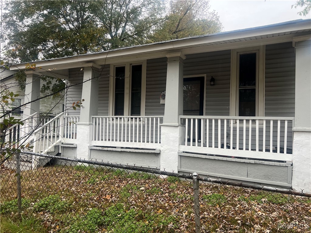 Entrance to property featuring covered porch