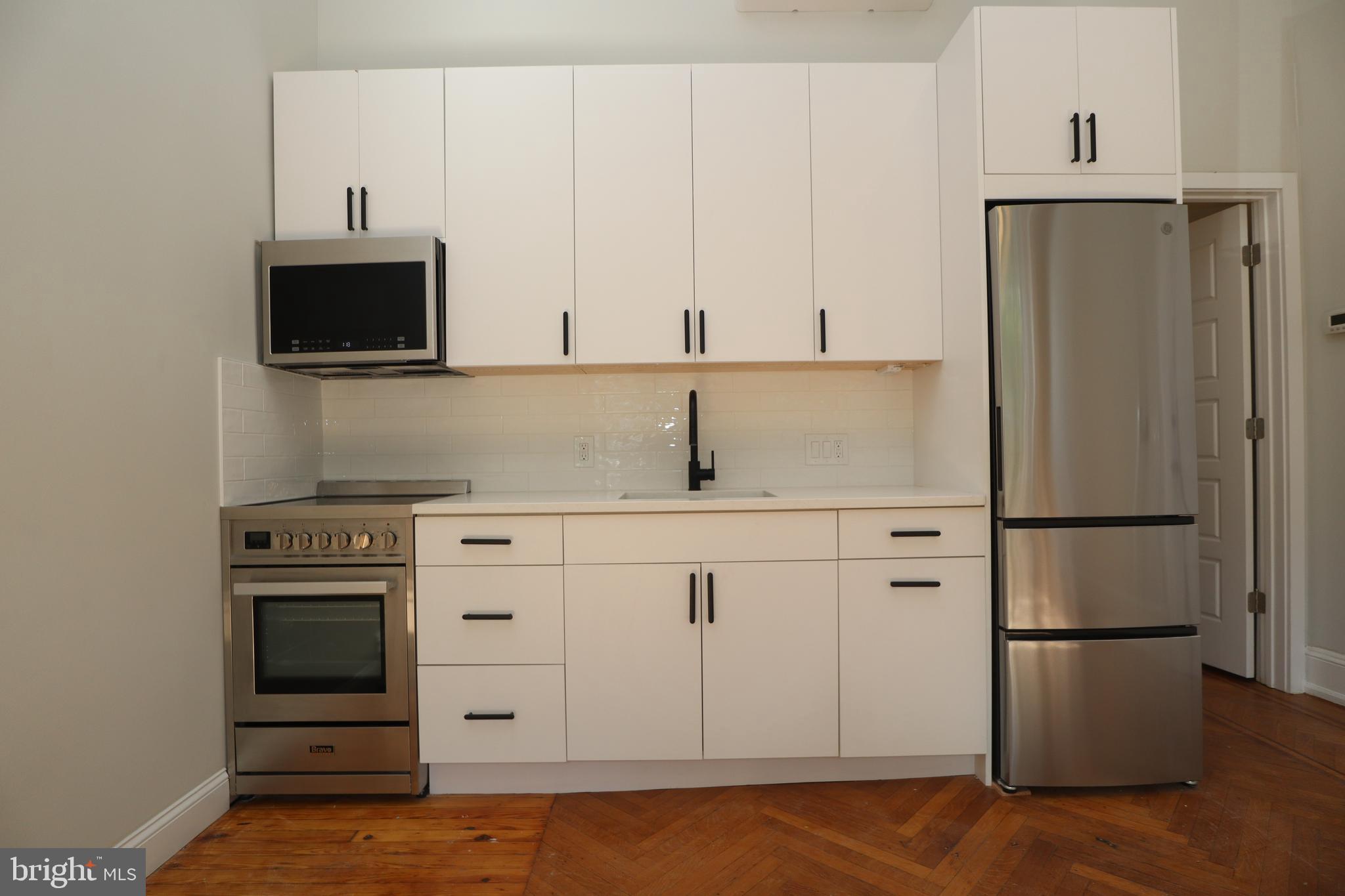 a kitchen with white cabinets and stainless steel appliances