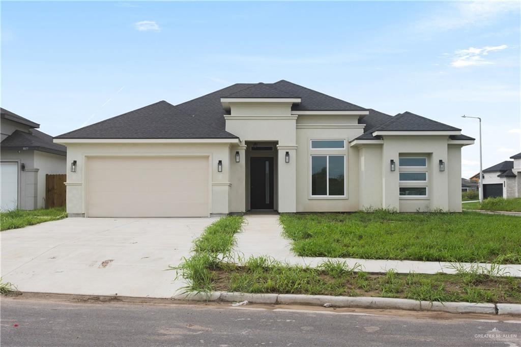 a front view of a house with a yard and garage