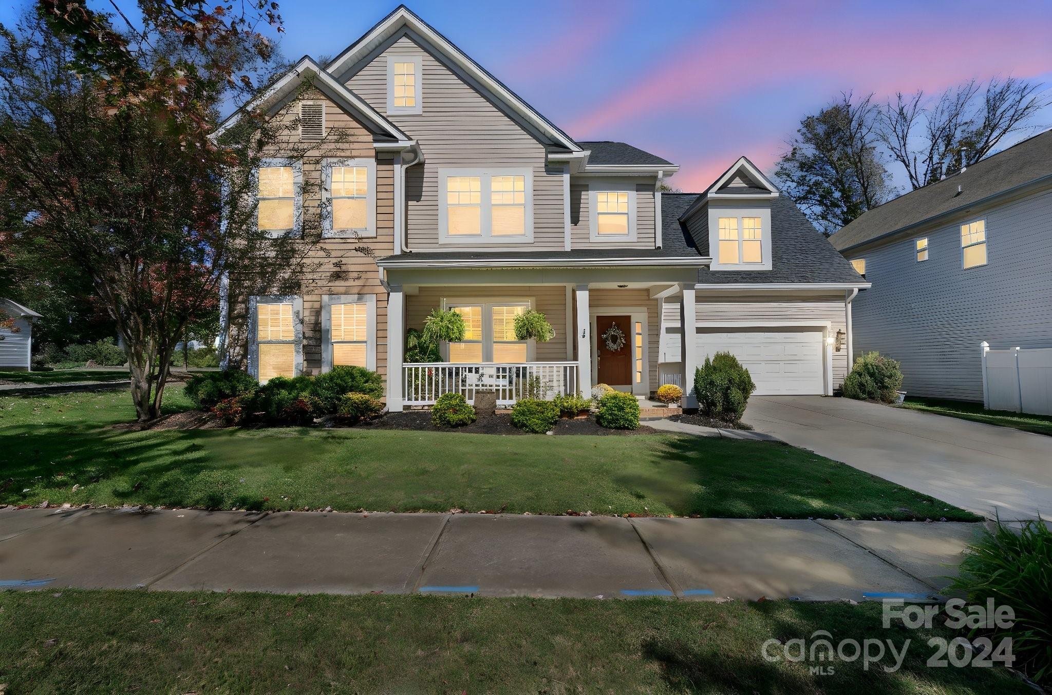 a front view of a house with a yard and trees