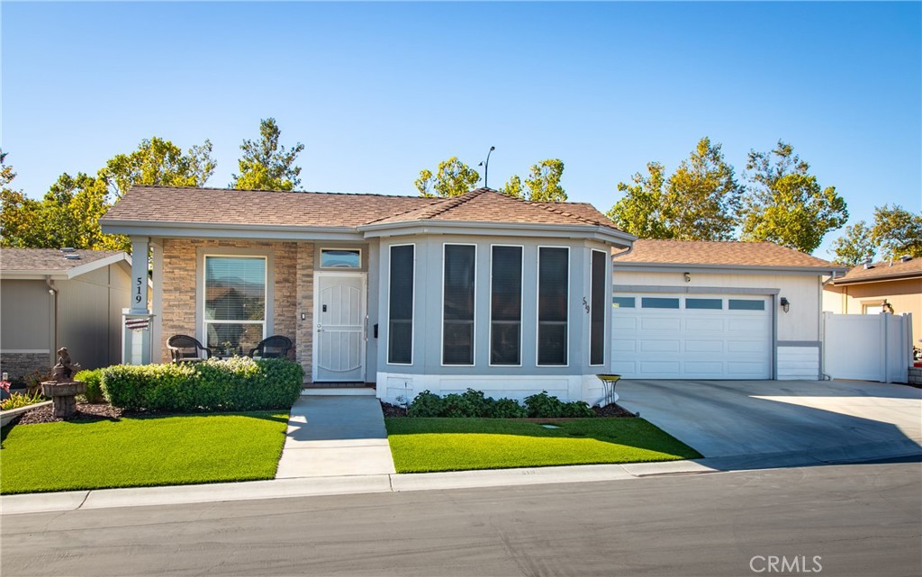 a front view of a house with a yard and potted plants