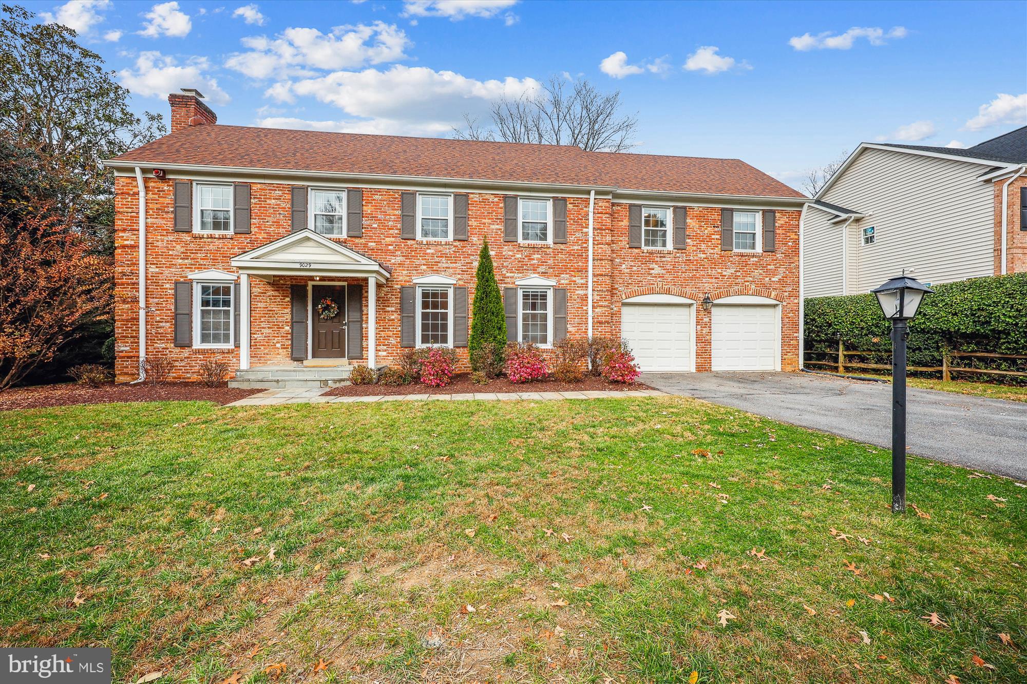 a front view of a house with a yard and trees