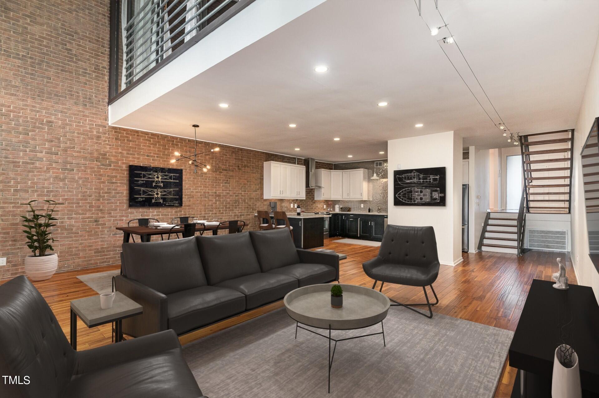 a living room with furniture kitchen view and a wooden floor