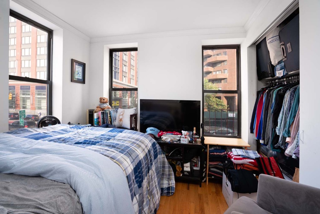 a bedroom with a bed and a flat tv screen on a dresser