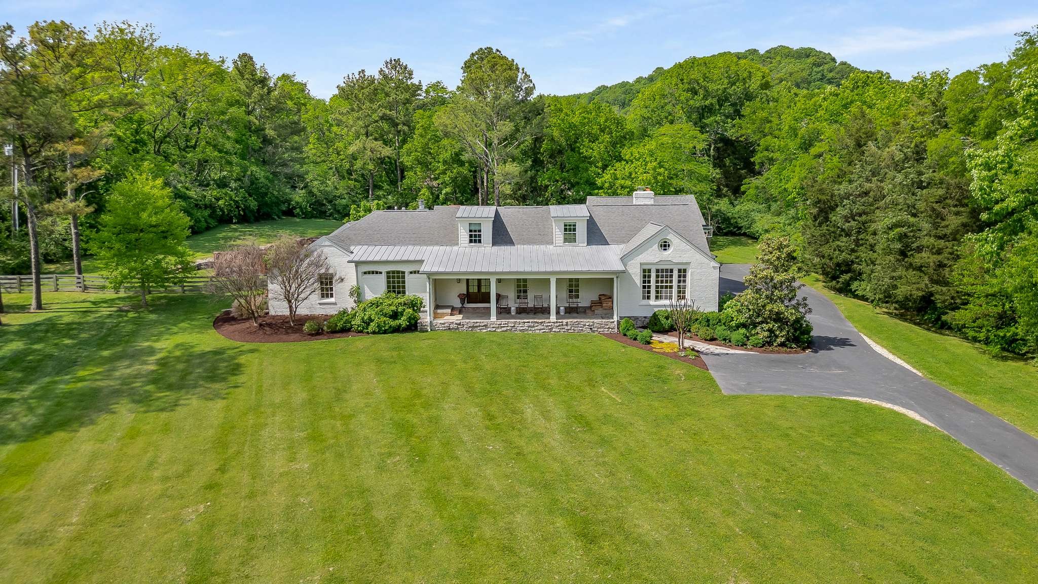 a aerial view of a house with swimming pool next to a big yard