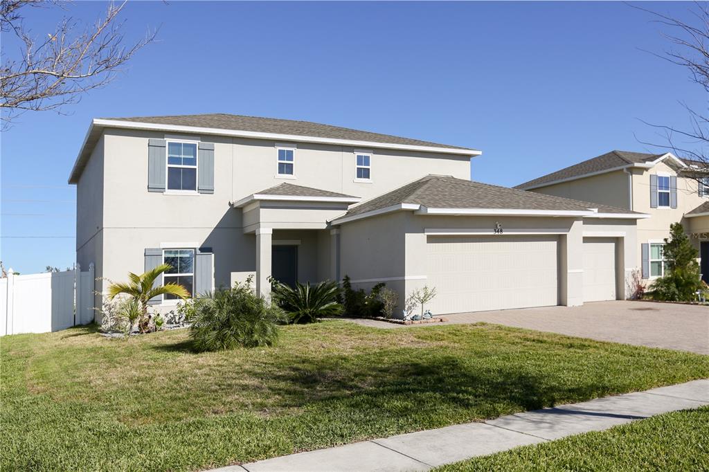 a front view of a house with a yard and garage