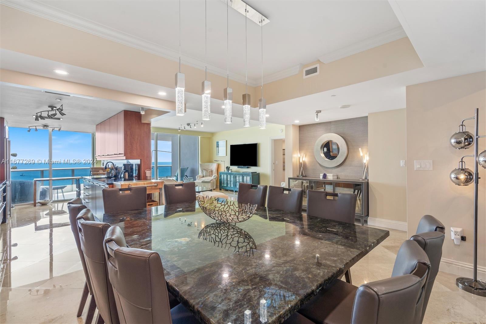 a view of a dining room with furniture a kitchen and chandelier