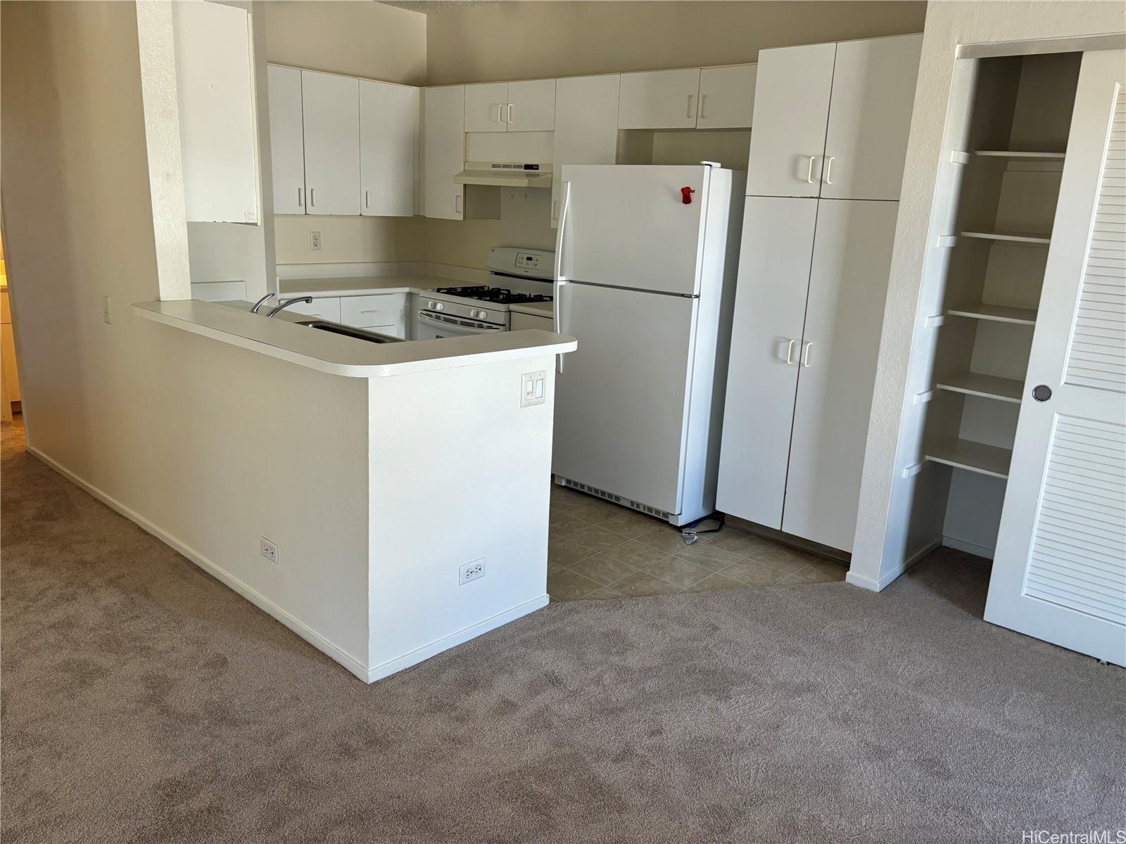 a kitchen with refrigerator a stove a sink and a window