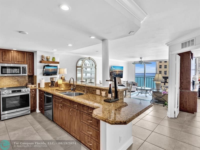 a kitchen with stainless steel appliances granite countertop a sink stove and cabinets