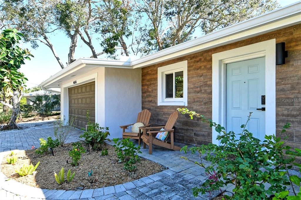 a front view of a house with porch and chairs