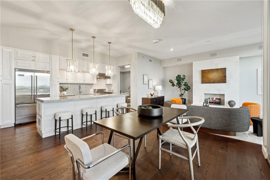 a kitchen with a dining table chairs wooden floor and appliances