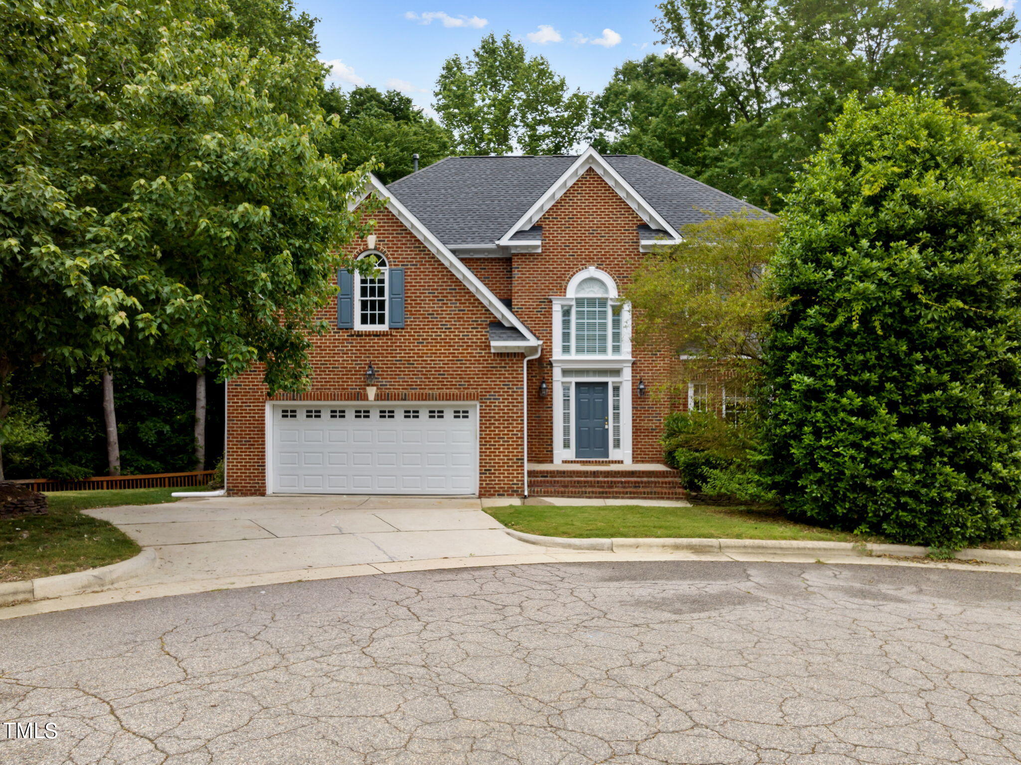 a front view of a house with a yard and trees