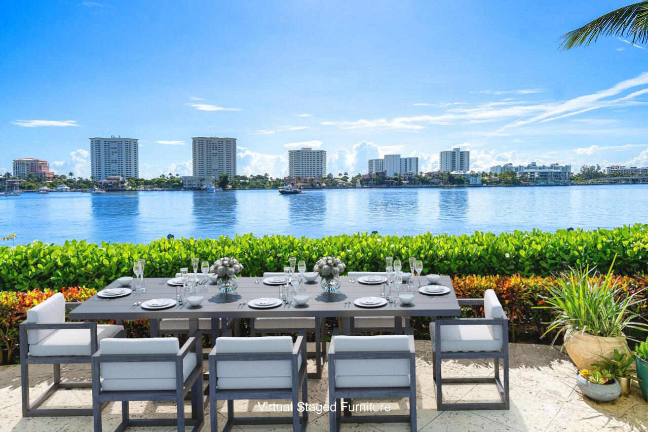 a patio with lake view and a yard