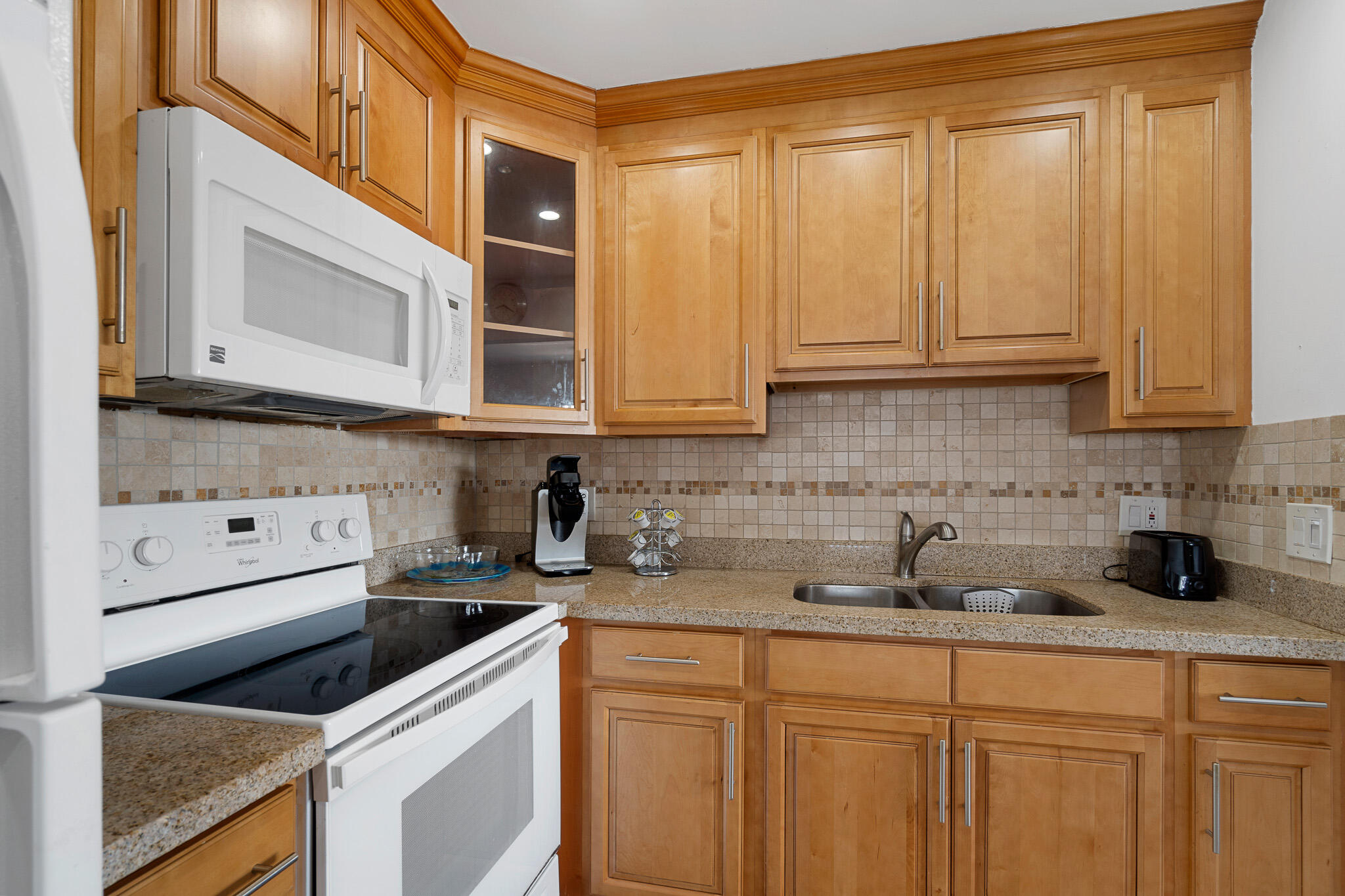 a kitchen with stainless steel appliances granite countertop a sink a stove and cabinets