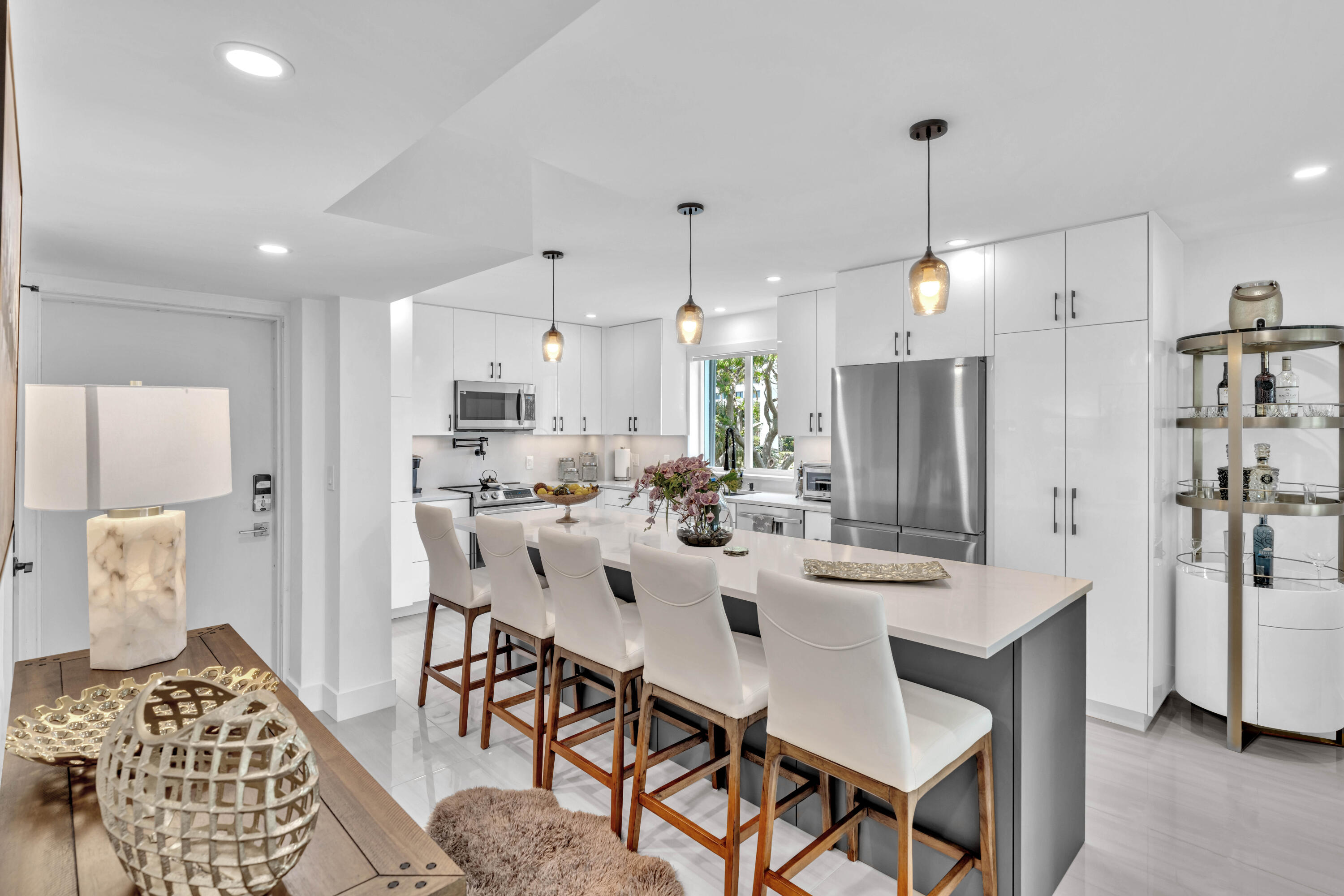 a kitchen with stainless steel appliances kitchen island granite countertop a dining table chairs and sink