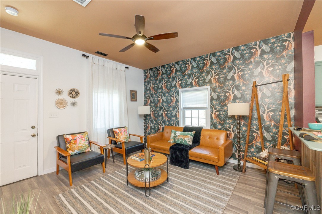 Living area with wood-type flooring and ceiling fa