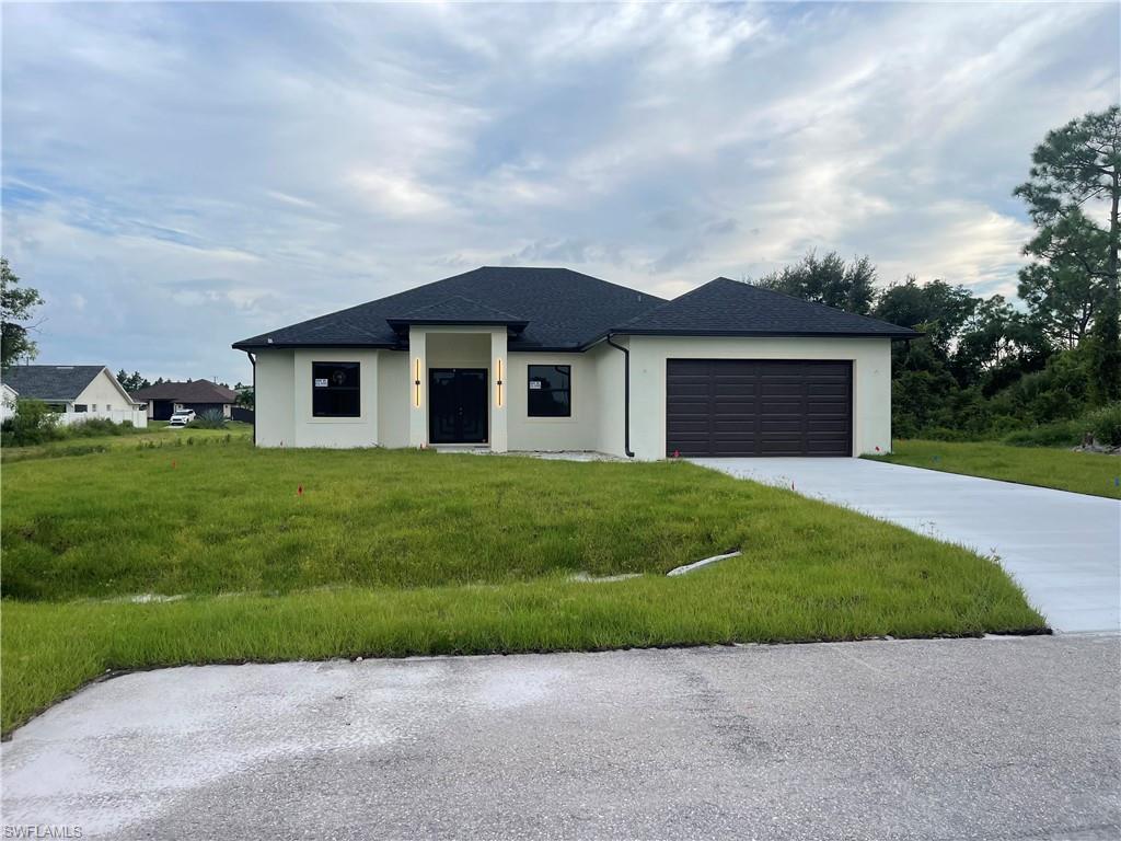 View of front of home featuring a front lawn and a garage