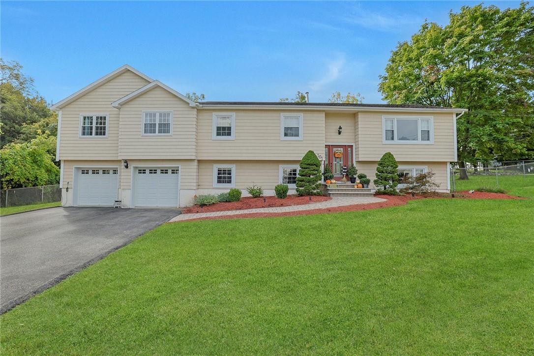 Split foyer home with a garage and a front lawn