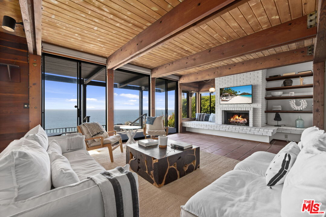 a living room with furniture large window and a fireplace