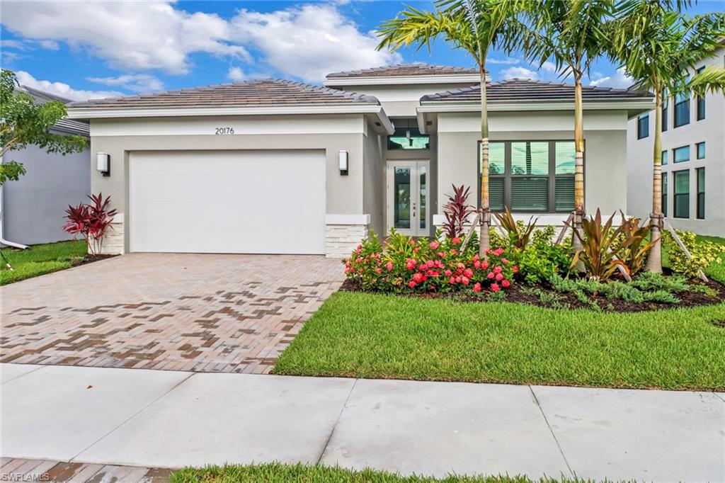 View of front facade with a garage and a front lawn