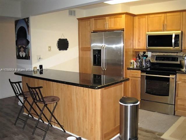 a kitchen with stainless steel appliances kitchen island a stove a refrigerator and a microwave