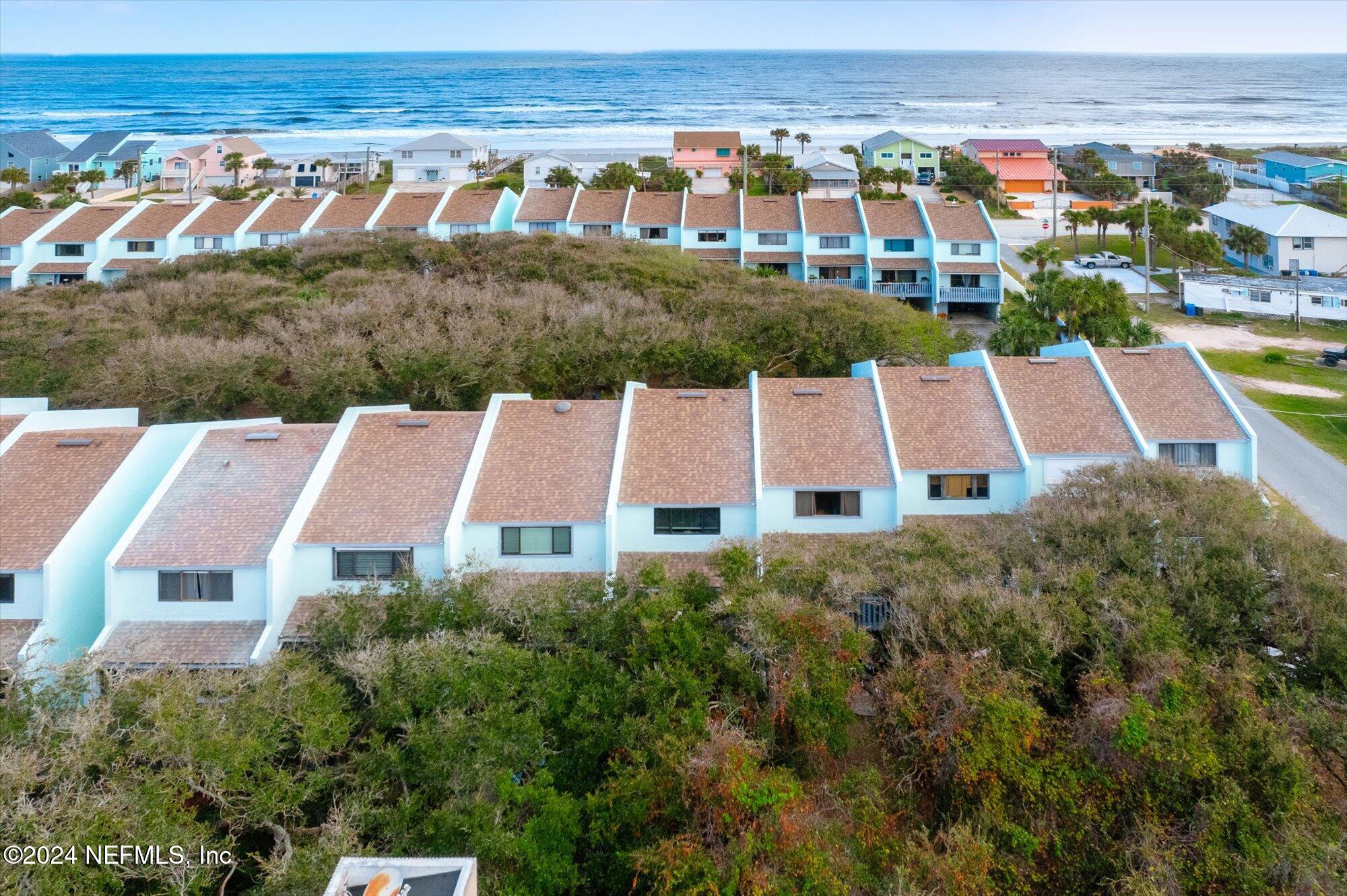 an aerial view of multiple houses with a yard