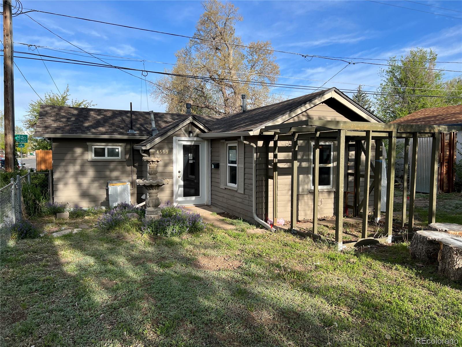 a view of a house with a small yard and wooden floor and fence