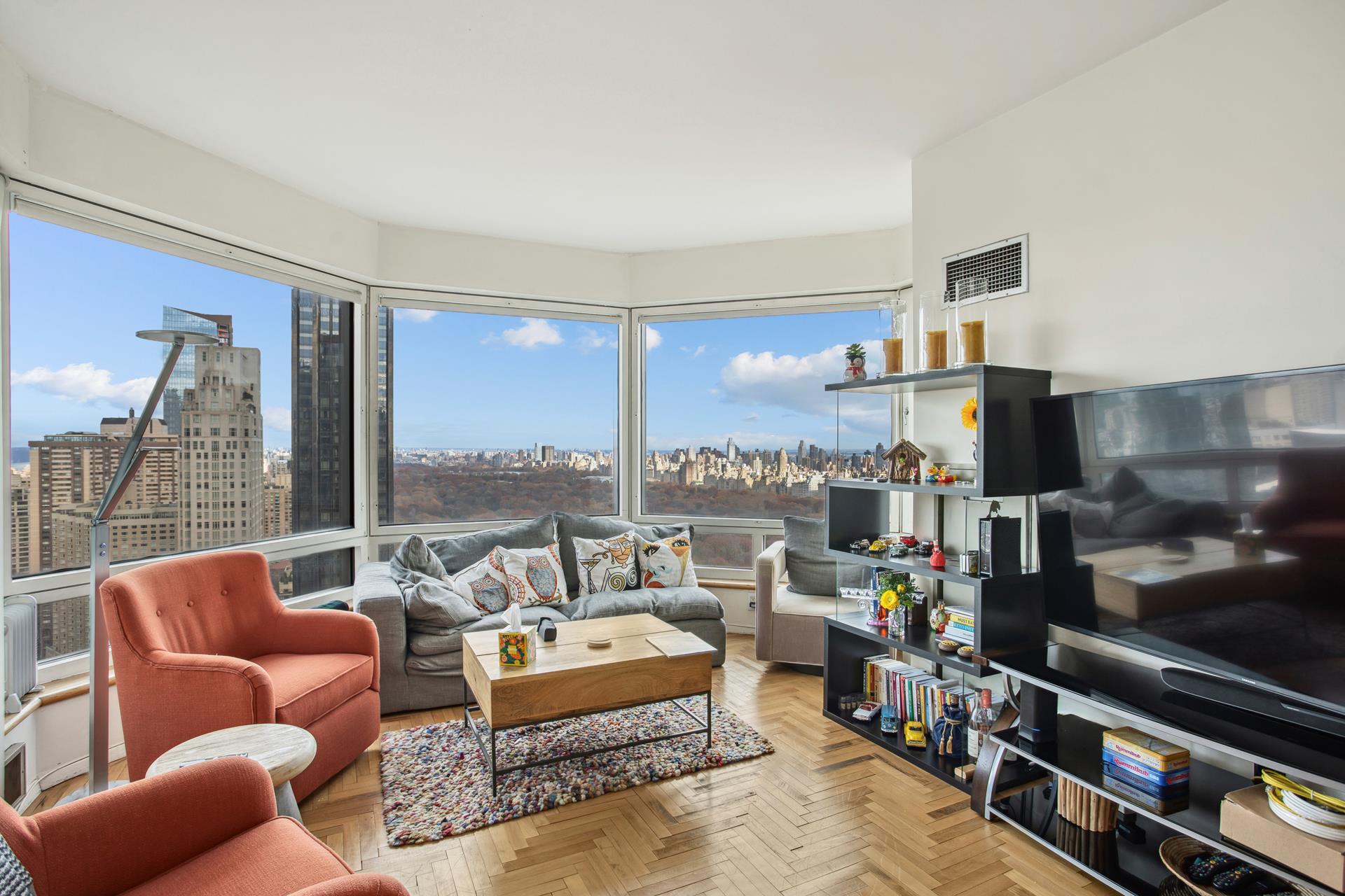 a living room with furniture a flat screen tv and a floor to ceiling window