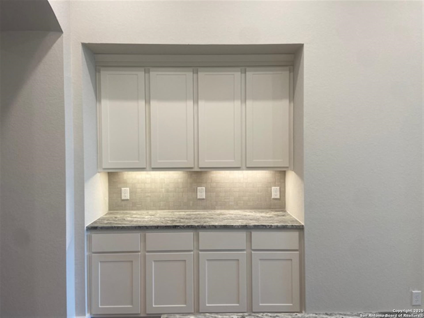 a bathroom with a granite countertop sink and cabinets