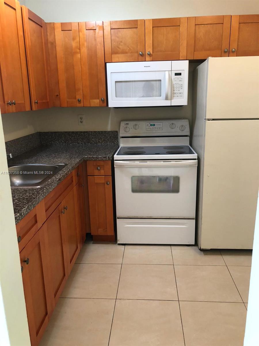 a kitchen with a stove top oven and cabinets