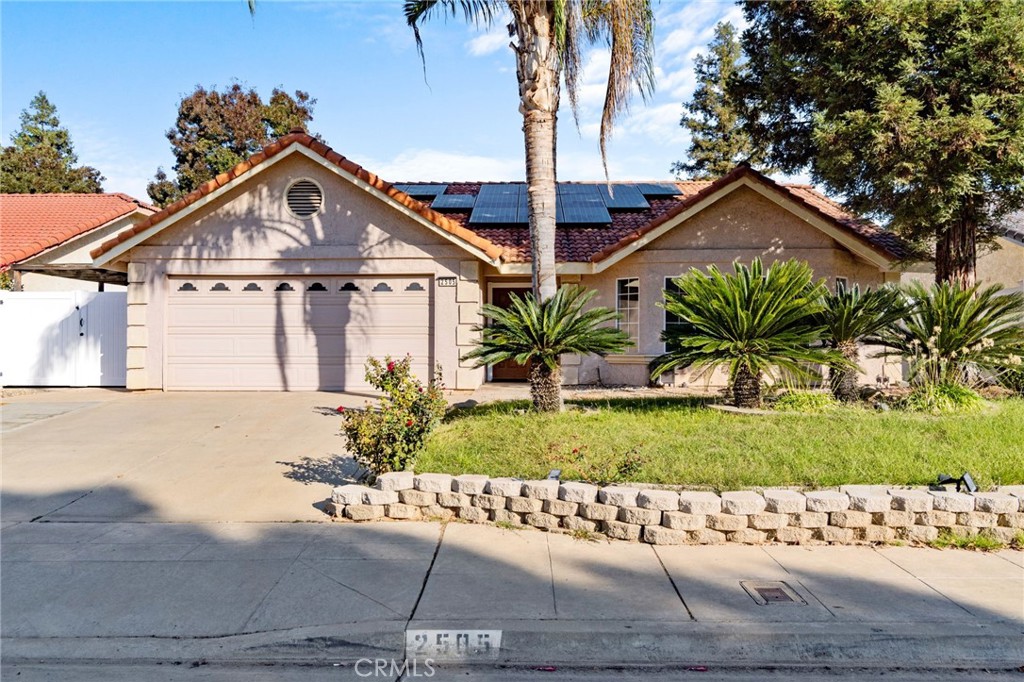 a front view of a house with a yard and potted plants