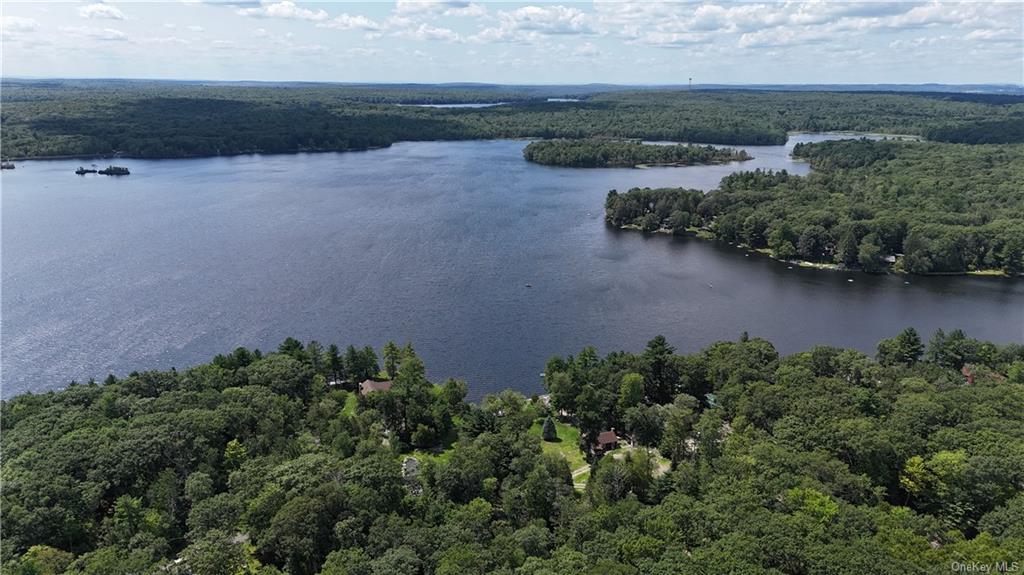 an aerial view of a house with a yard and lake view