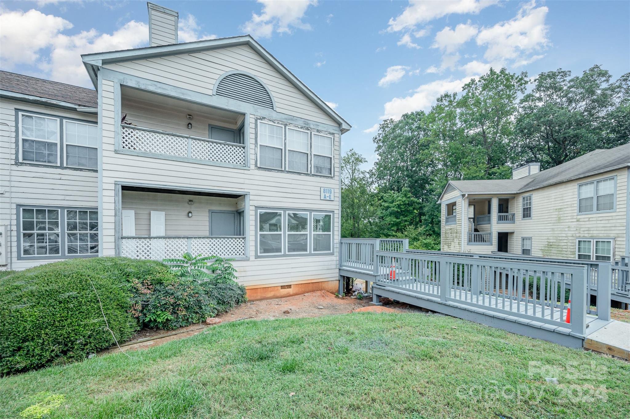 a view of a house with a yard and deck