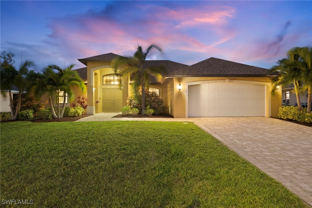 a front view of a house with a yard and a garage