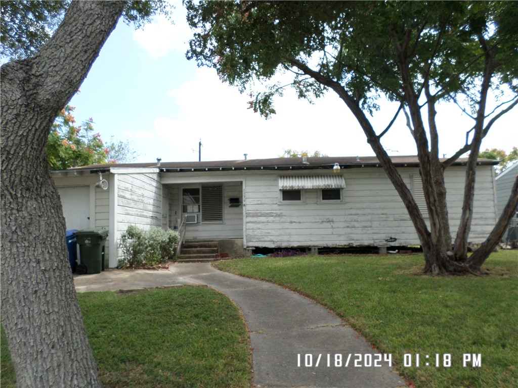 a view of a yard in front of a house with a large tree