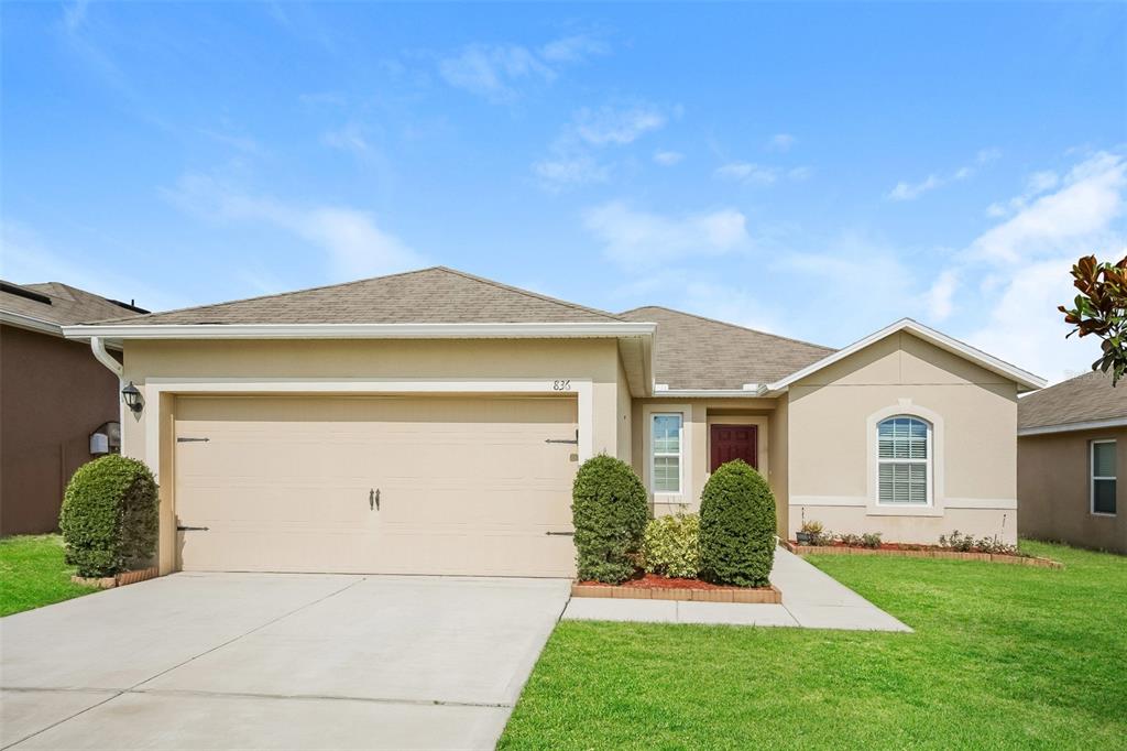 a front view of a house with a yard and garage