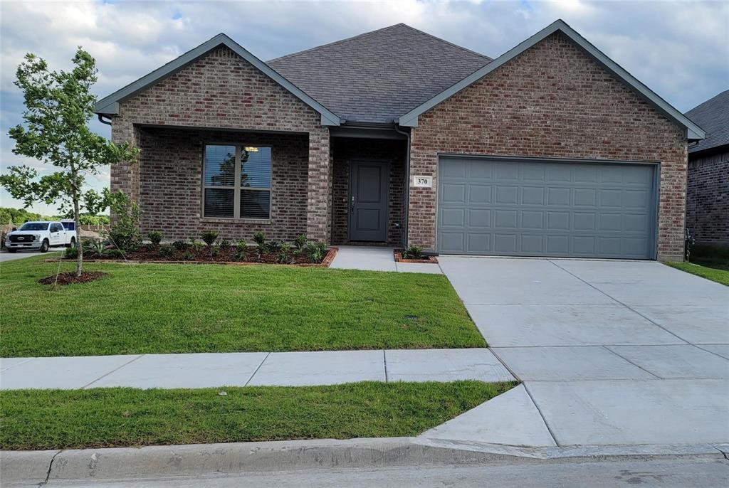 a front view of a house with a garden and yard