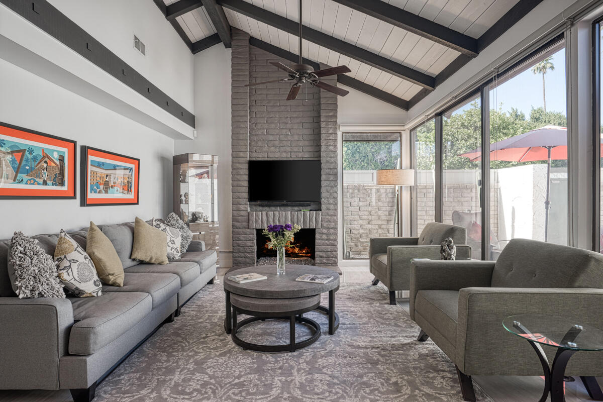 a living room with furniture a large window and a flat screen tv