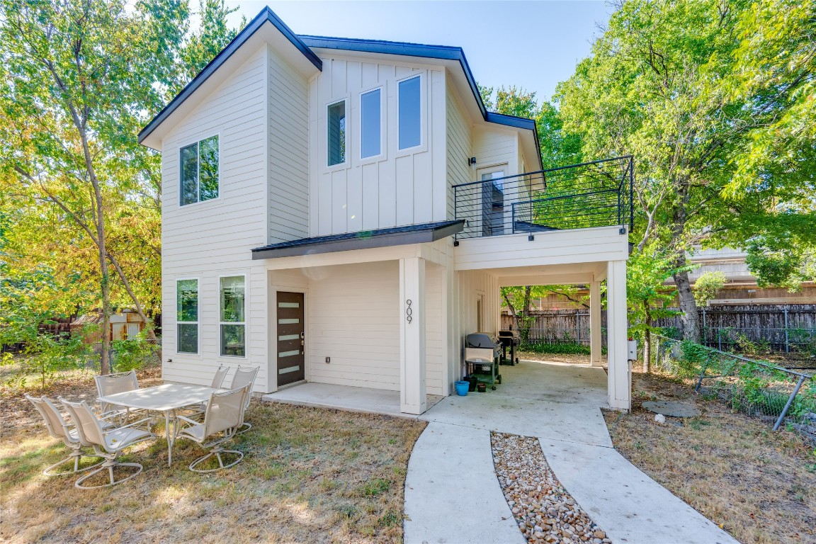 a view of a house with backyard and sitting area