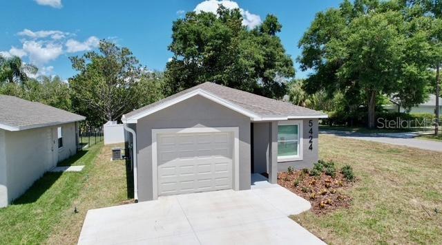 a front view of house with yard and trees in the background