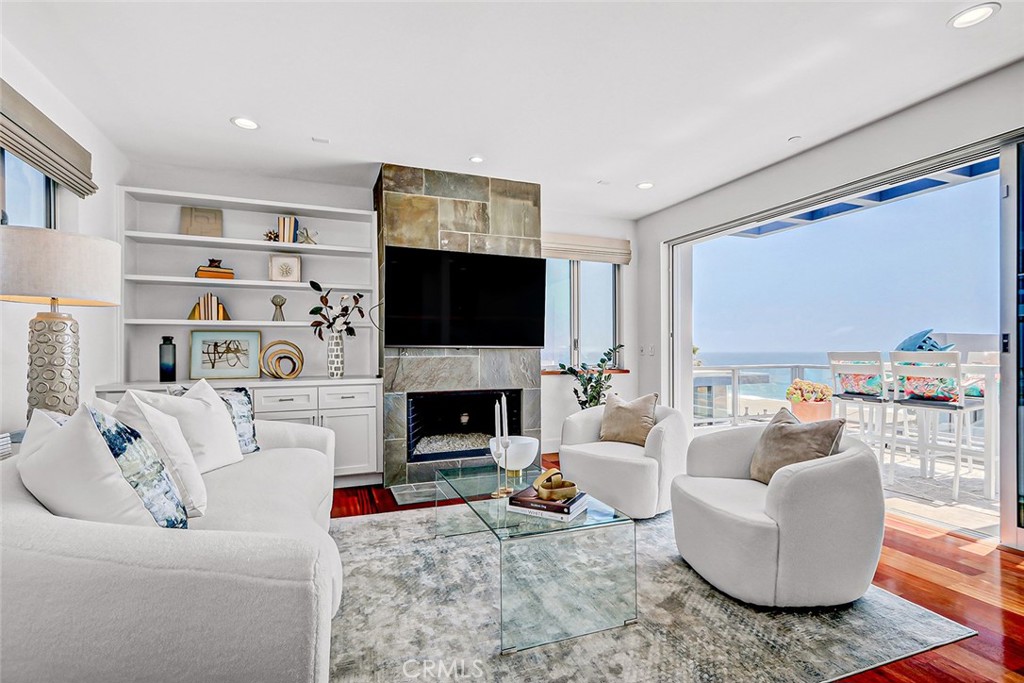 a living room with furniture a flat screen tv and a fireplace