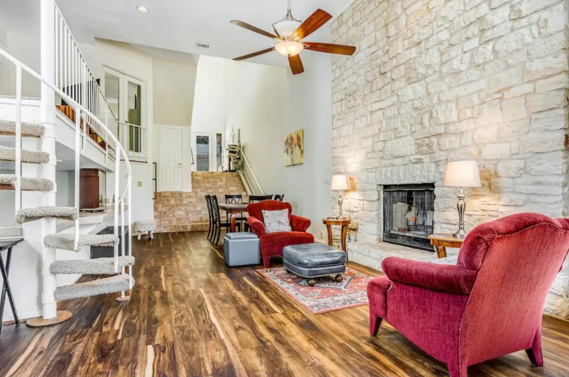 a living room with furniture fireplace and wooden floor