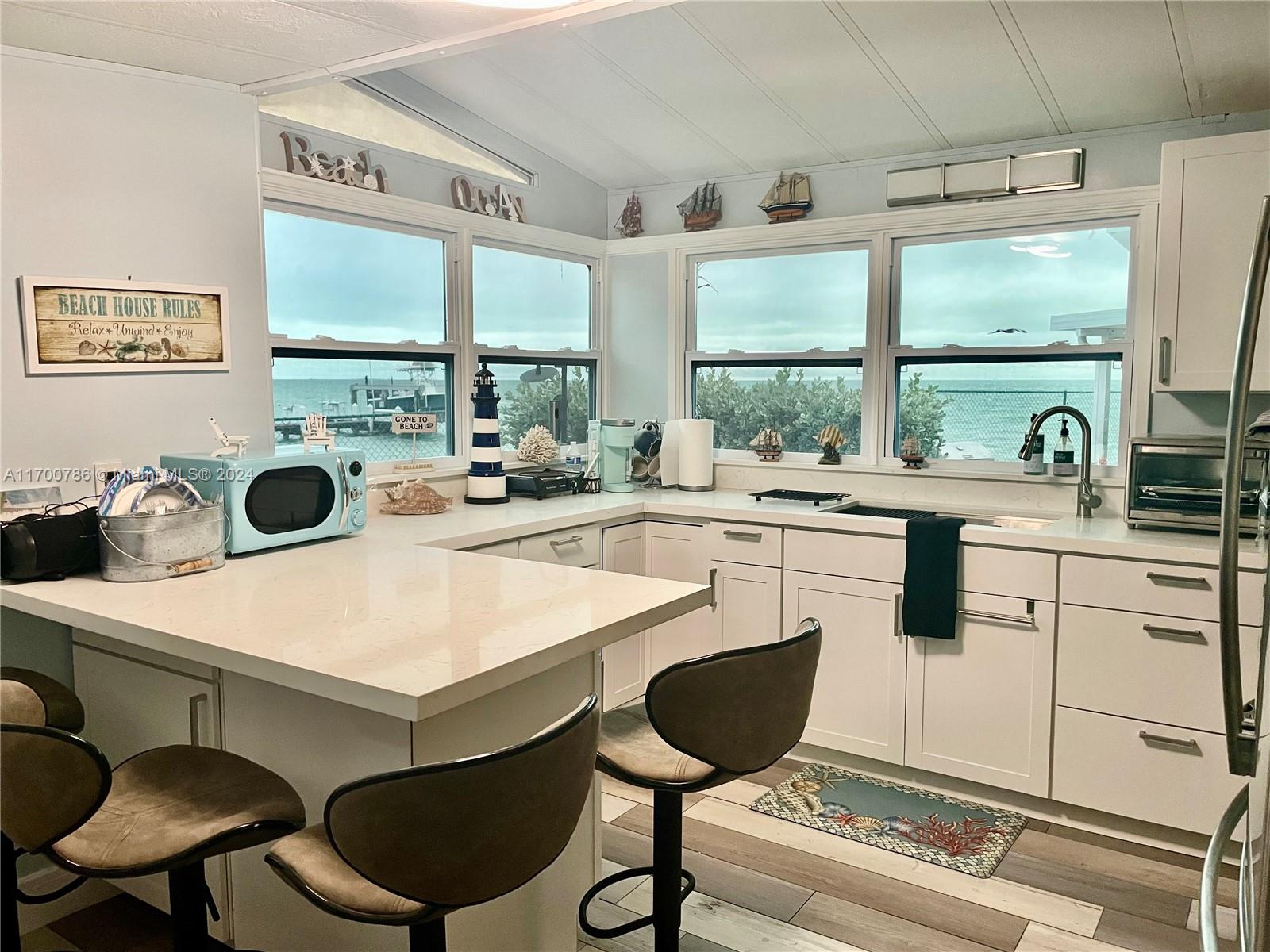 a kitchen with a stove a sink and a dining table with large windows